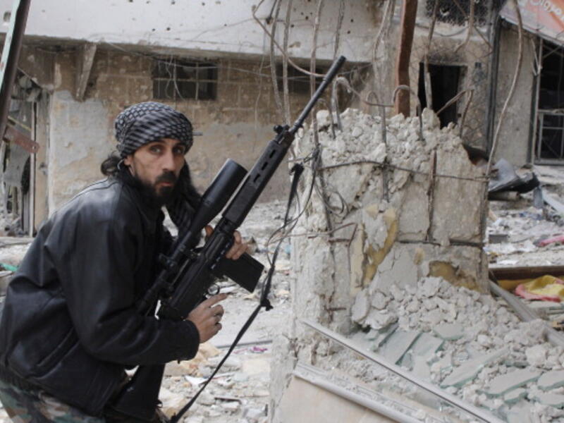 A rebel fighter from the Free Syrian Army holds a position with a Belgium made FAL rifle at a front line in the Salah al-Din neighbourhood of the northern Syrian city of Aleppo, on December 1, 2013. [Getty Images]