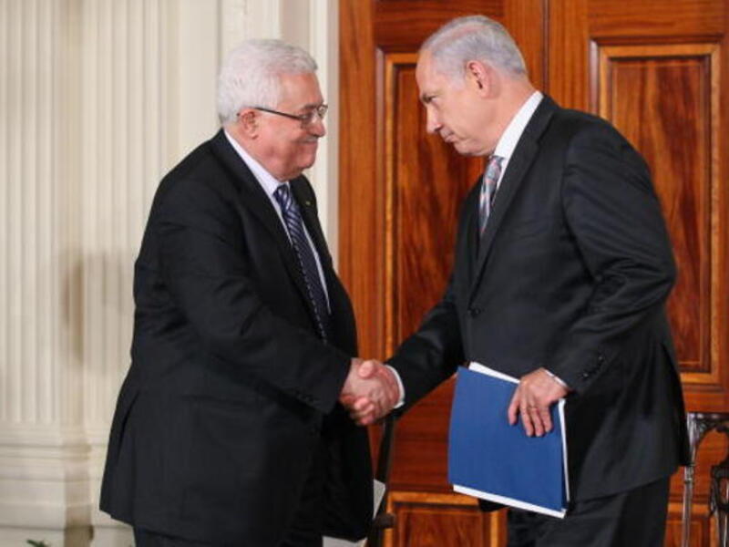 Palestinian Authority President Mahmoud Abbas (L) shakes hands with Israeli Prime Minister Benjamin Netanyahu.