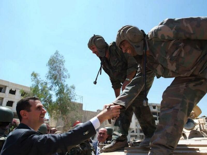 Syrian President Bashar Assad greets Syrian army soldiers during a visit in Daraya, southwestern of the capital Damascus on 1st August. (AFP/SANA)