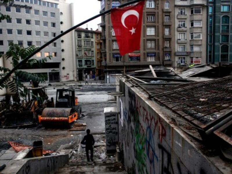 People walk next to Taksim's Gezi Park early on Wednesday in Istanbul, hours after riot police invaded the square. AFP image.
