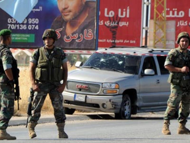 Lebanese soldiers at the site of a car bomb attack on a Hezbollah convoy travelling towards the border crossing with Syria on Tuesday. [ AFP]
