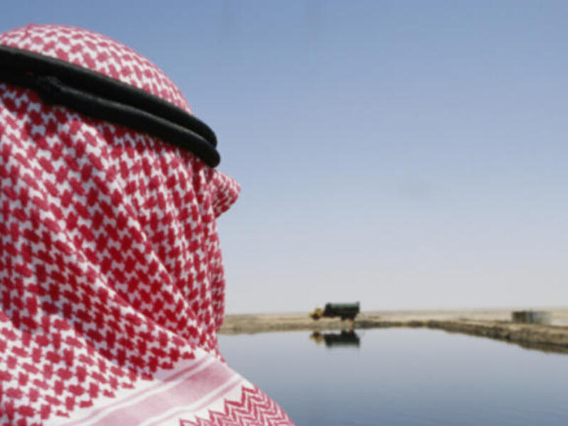 Man in headdress overseeing oil retention pond