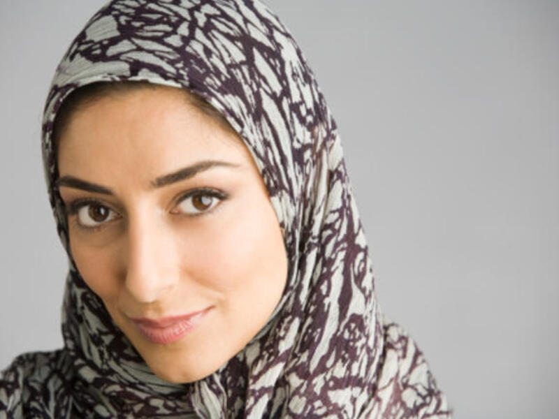 A Muslim woman smiles.