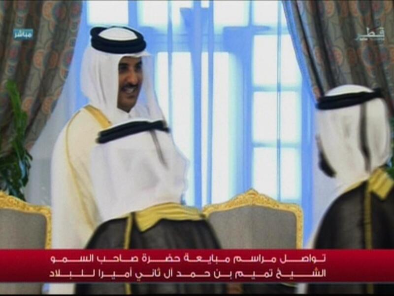 The new Emir of Qatar, 33-year-old Sheikh Tamim, shakes hands with his subjects as they swear allegiance to him on Tuesday. (AFP/Qatar TV)