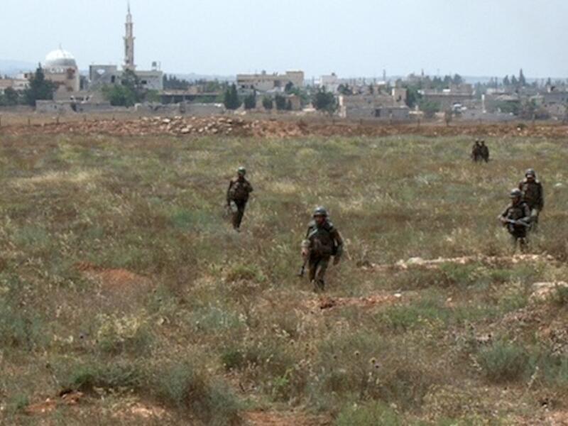  Syrian army soldiers walking nearby facilities of Dabaa military airfield during an operation that led to the control of the airport, north of the Syrian city of Qusayr. AFP Photo
