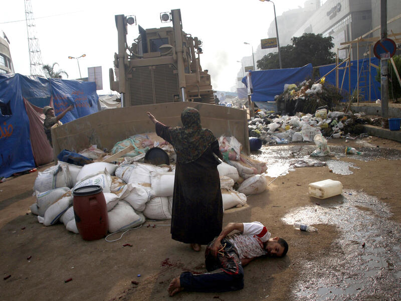 An Egyptian woman tries to stop a military bulldozer (AFP/MOHAMMED ABDEL MONEIM)