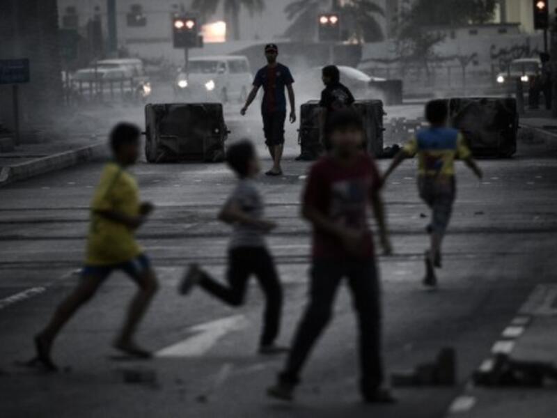 Bahraini boys run for cover during clashes following an anti-regime rally in support of political activists held in prison in the village of Jidhafs, west of Manama on Monday. (Photo:  AFP /MOHAMMED AL-SHAIKH) - Photo used for illustrative purposes - 