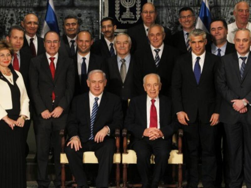 Israeli President Shimon Peres (C-R, seated) sits next to Prime Minister Benjamin Netanyahu (C-L, seated) as they pose for a group photo with the ministers of the new Israeli government in Jerusalem on Monday. (Photo: AFP PHOTO/POOL/RONEN ZVULUN) 