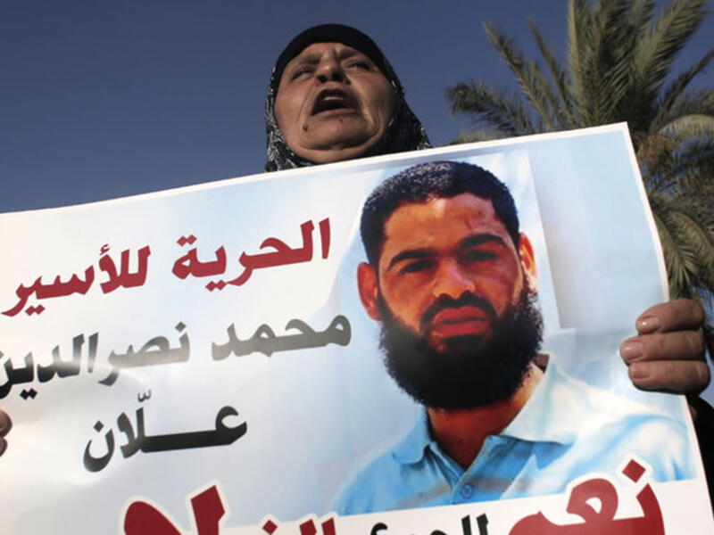 Maazouze, the mother of Muhammad Allan, a Palestinian prisoner who is on a long-term hunger strike, holds a portrait of her son during a rally calling for his release in the southern Israeli city of Beersheva on August 9, 2015. (AFP/Ahmad Gharabli)