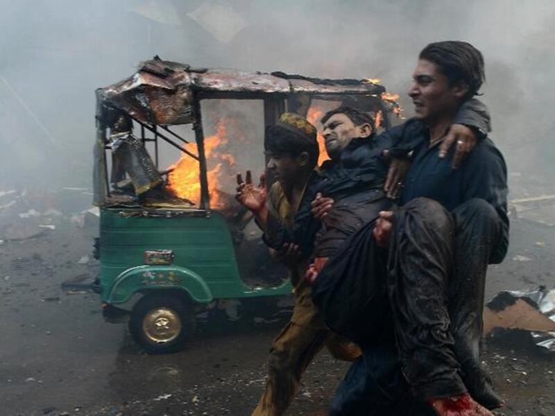 Pakistani men carry an injured blast victim at the site of a bomb explosion in the busy Kissa Khwani market in Peshawar in September. [AFP]