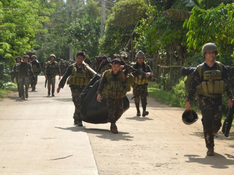 Philippine soldiers carry a body bag containing the body of a member of militant group Abu Sayyaf after their armed encounter at the village of Bongkaong, Patikul town, Sulu province on the southern island of Mindanao on August 26, 2016. (AFP/Stringer)