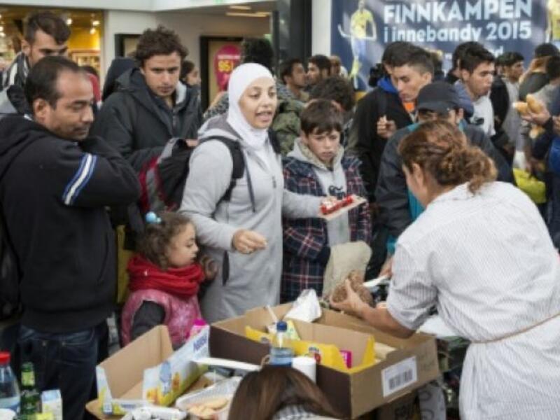 Refugees in Sweden receive food from an aid worker. (AFP/File)
