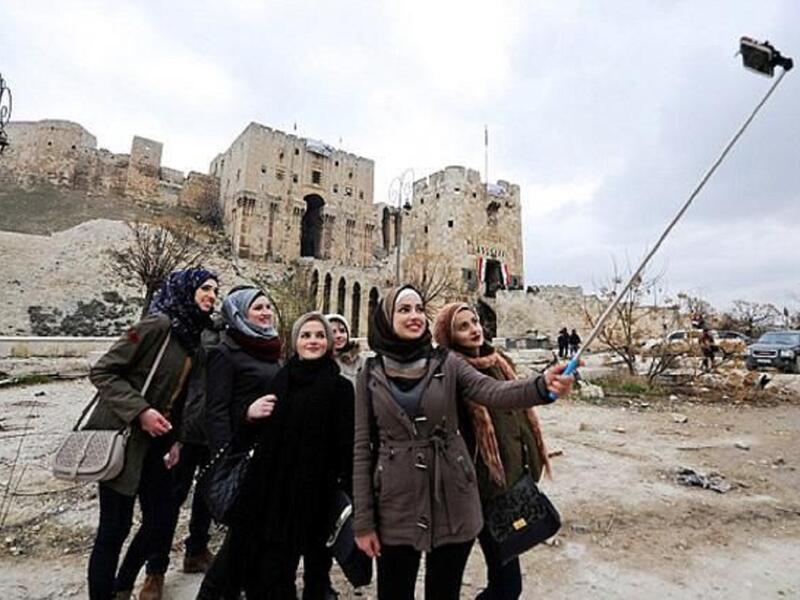 سيلفي حلب المنكوبة
التقطت مجموعة من النساء صور "سيلفي" من أمام القلعة التاريخية الموجودة داخل مدينة حلب، وسط ركام المباني والسيارات المدمرة.