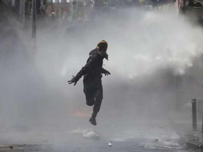 رجل مقنع يهرب بعد استعمال الشرطة سياسة التفريق بالمياه خلال مظاهرات شهدتها اسطنبول بتركيا بين الشرطة ومعارضين لمنع الحكومة المتظاهرين من المسير لساحة تقسيم، المظاهرات كانت بمناسبة يوم العمال العالمي.