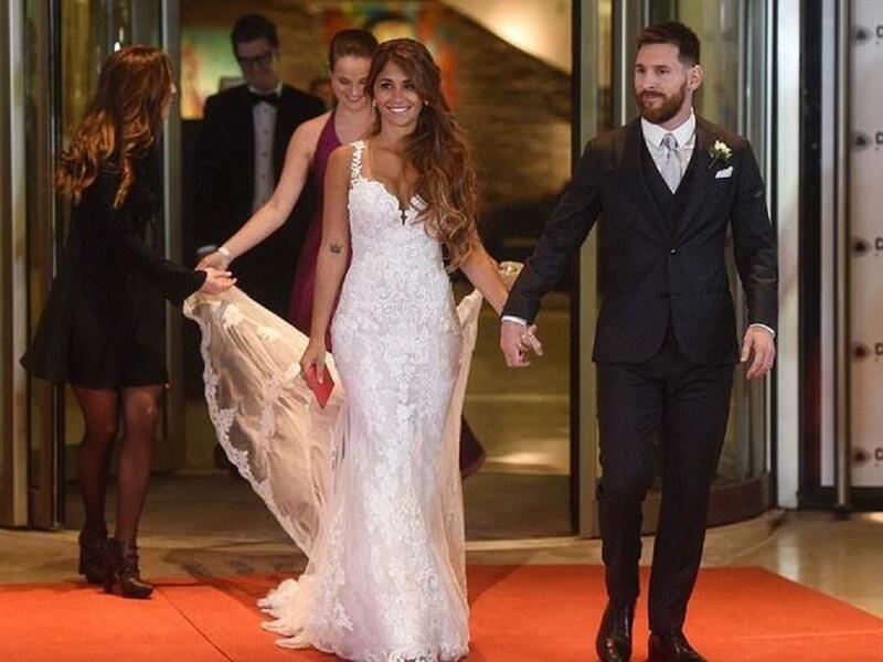 نجم منتخب الأرجنتين ونادي برشلونة الإسباني ليونيل ميسيي وزوجته أنطونيلا روكوزو يدخلان قاعة الزفاف وخلفهما شقيقة العروس تحمل ذيل الفستان.
