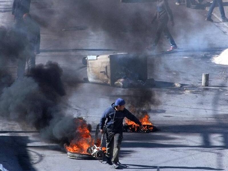 Tunisian demonstrators block the road with burning tires in the central city of Kasserine during protests, on 21 January, 2016, triggered by the death of an unemployed man. (AFP/ Mohamed Khalil)