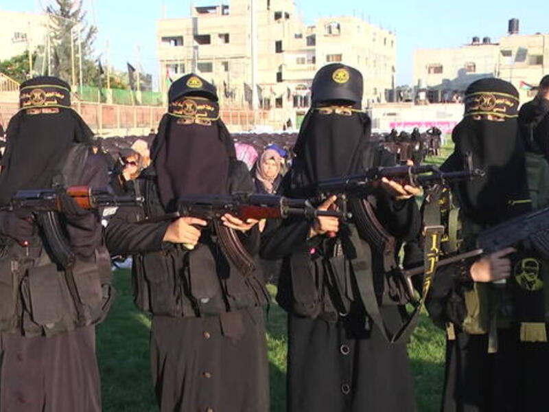 The women with their weapons during the exercise as spectators look on (i.dailymail)