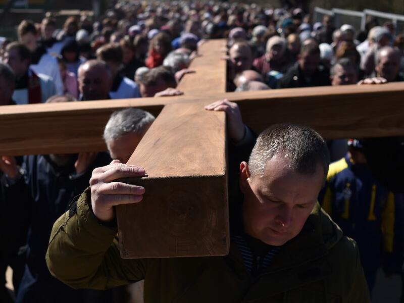 Catholic believers carry a giant cross on April 14, 2019 in the town of Ashmiany, some 130 km northwest of Minsk, during a Palm Sunday celebration which mark a week before eastern.  Sergei GAPON / AFP