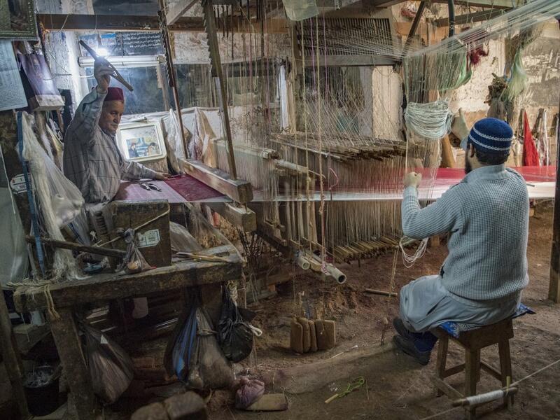 Abdelkader Ouazzani, the last of Morocco's brocade master weavers, displays tapestry at his workshop in the old city of Fez on April 10, 2019. His skilfull hands intricately create shimmering silk fabrics, enhanced with gold or silver thread, for bridal jewellery, designer creations or high-end furnishings. FADEL SENNA / AFP