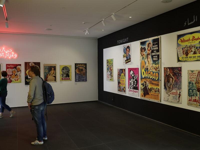 Visitors observe vintage cinema posters displayed at an art exhibition in the Lebanese capital Beirut  JOSEPH EID / AFP