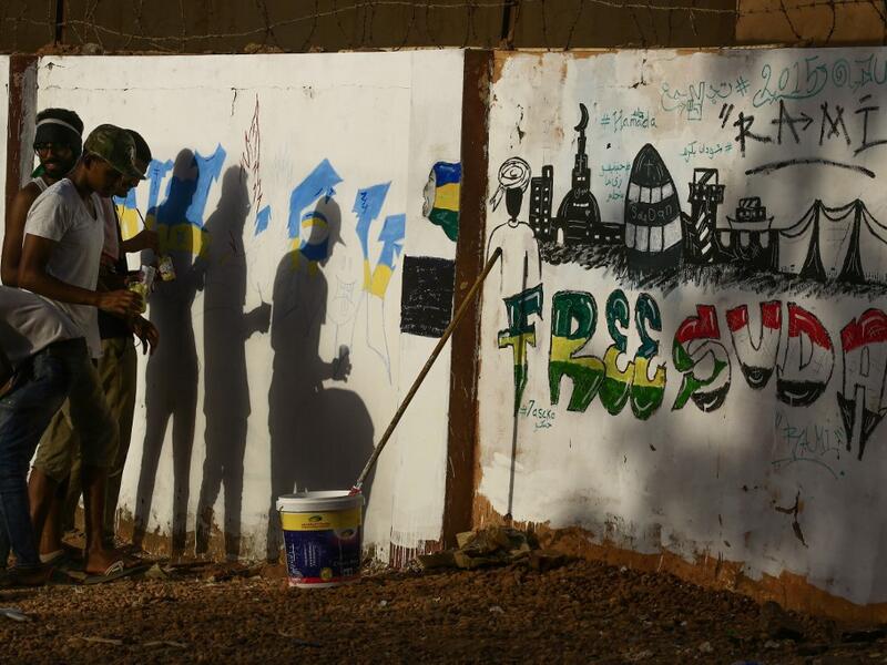 Sudanese protesters paint a graffiti during a "million-strong" march outside the army headquarters in the capital Khartoum. ASHRAF SHAZLY / AFP