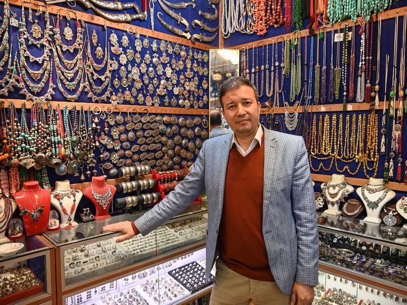 Expert Afghan jeweler Khalil Nuri poses for a picture in his shop at the Grand Bazaar in Istanbul.   OZAN KOSE / AFP