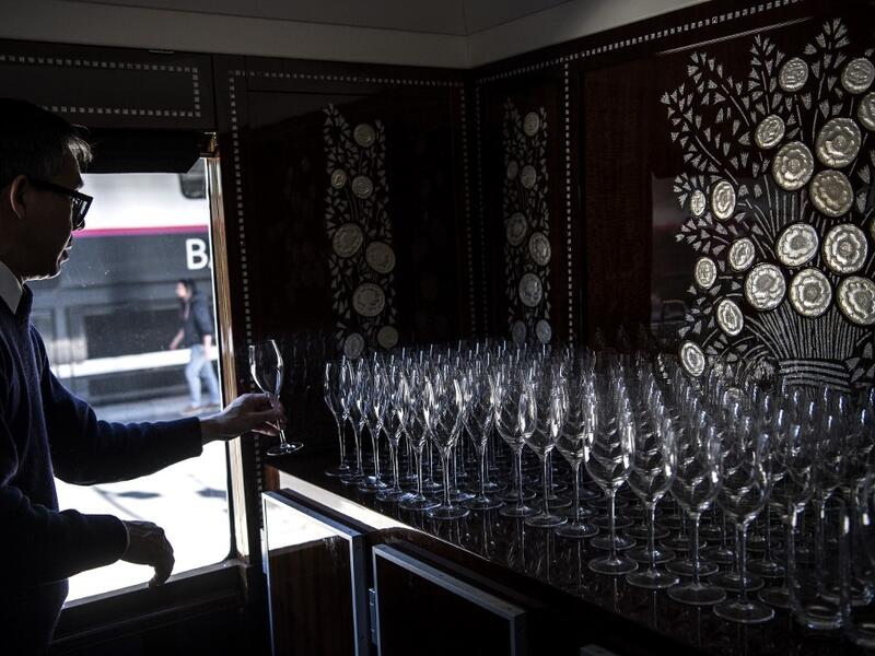 This picture taken on May 13, 2019 shows a bartender lining up glasses in the dining car of a restored carriage of an Orient Express train displayed at the Gare de l'Est train station in Paris.  Christophe ARCHAMBAULT / AFP