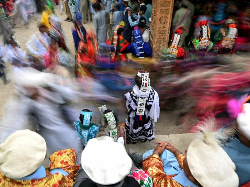 In a remote valley in Pakistan dozens of Kalash minority women dance to celebrate spring's arrival -- but as a gaggle of men scramble to catch them on camera, the community warns an influx of domestic tourists is threatening their unique traditions.  AAMIR QURESHI / AFP