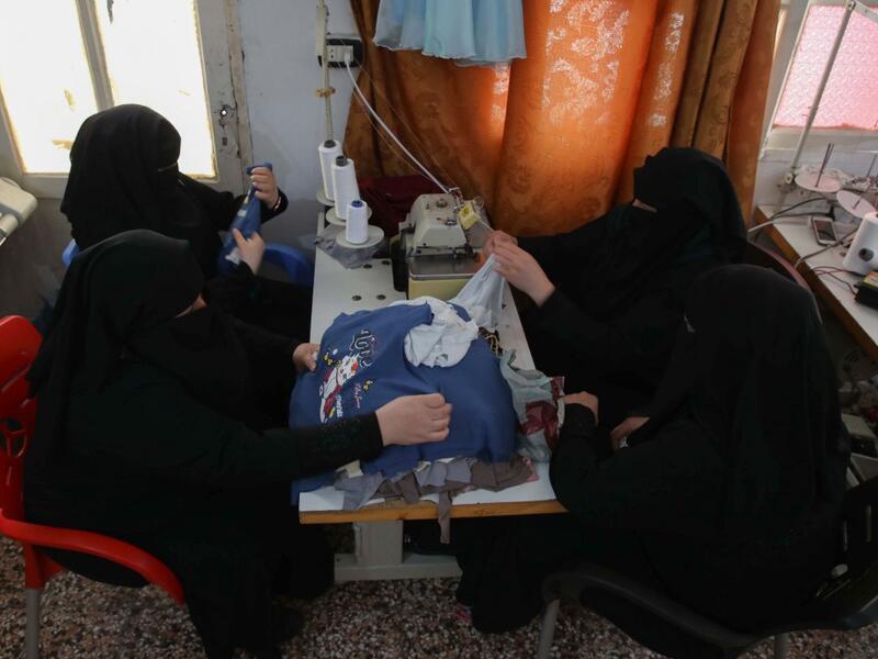 Colleagues of Hasna Dbeis (unseen), a 30-year-old former detainee in a Syrian-regime jail, work at a sewing workshop employing former female detainees, in the town of Maarat Nasrin, in the rebel-held part of the Syrian Idlib  Aaref WATAD / AFP
