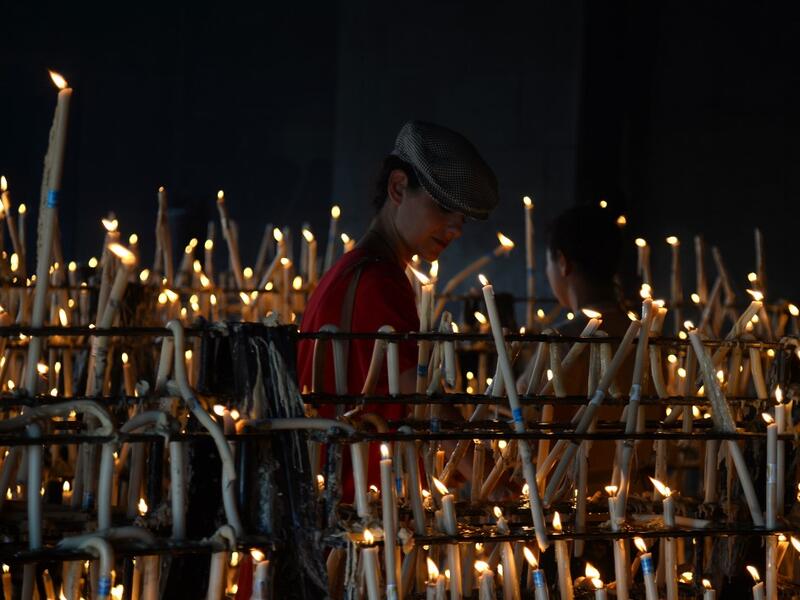A pilgrim lights a candle at the church of the village of El Rocio.  CRISTINA QUICLER / AFP