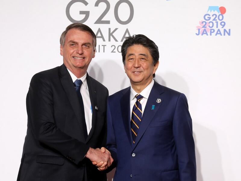 Brazil's President Jair Bolsonaro (L) is welcomed by Japan's Prime Minister Shinzo Abe to the G20 Summit in Osaka on June 28, 2019.  Ludovic MARIN / POOL / AFP