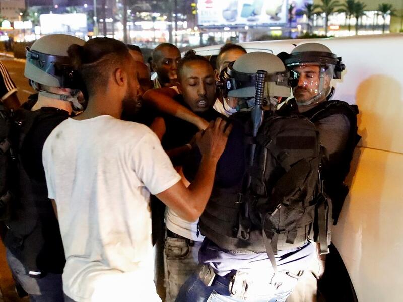 Members of the Ethiopian community of Israel face policemen during clashes in the Israeli coastal city of Netanya, during a protest against the killing of Solomon Tekah, a young man of Ethiopian origin, who was killed by an off-duty police officer.  JACK GUEZ / AFP