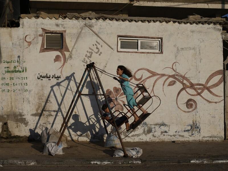 Palestinian children play on a swing at Al-Shatee Refugee Camp in Gaza City on July 3, 2019.  MOHAMMED ABED / AFP