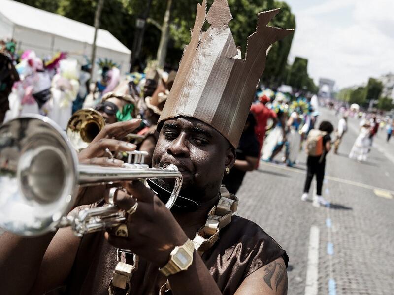People parade during the Tropical Carnival on July, 7 2019 in Paris.  Kenzo TRIBOUILLARD / AFP
