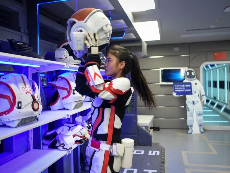 A guide wearing a spacesuit puts on a helmet at "Mars Base 1", a C-Space Project, in the Gobi desert, some 40 kilometres from Jinchang in China's northwest Gansu province on April 17, 2019. WANG ZHAO / AFP