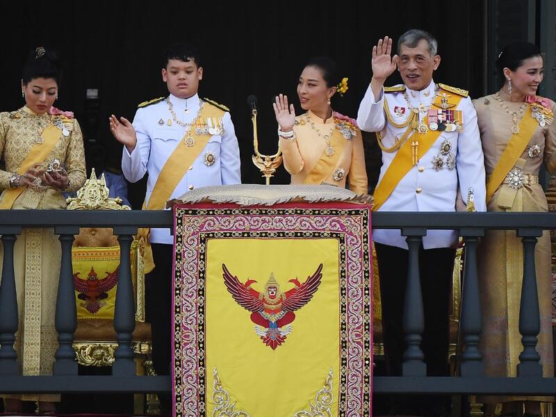 (From L to R) Thailand's Princess Sirivannavari Nariratana uses her mobile phone as her brother Prince Dipangkorn Rasmijoti, sister Princess Bajrakitiyabha Mahidol, father King Maha Vajiralongkorn and Queen Suthidawave to well-wishers from the balcony of Suddhaisavarya Prasad Hall. Jewel SAMAD / AFP