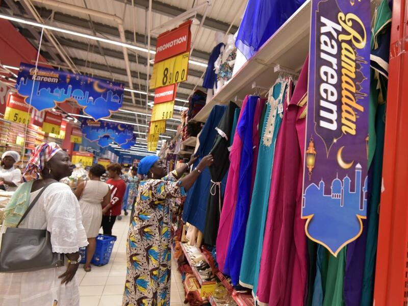 Women look at dresses at the Carrefour supermarket in Abidjan on May 4, 2019 on the eve of the start of the Ramadan, the Muslim holy month of fasting.  Sia KAMBOU / AFP