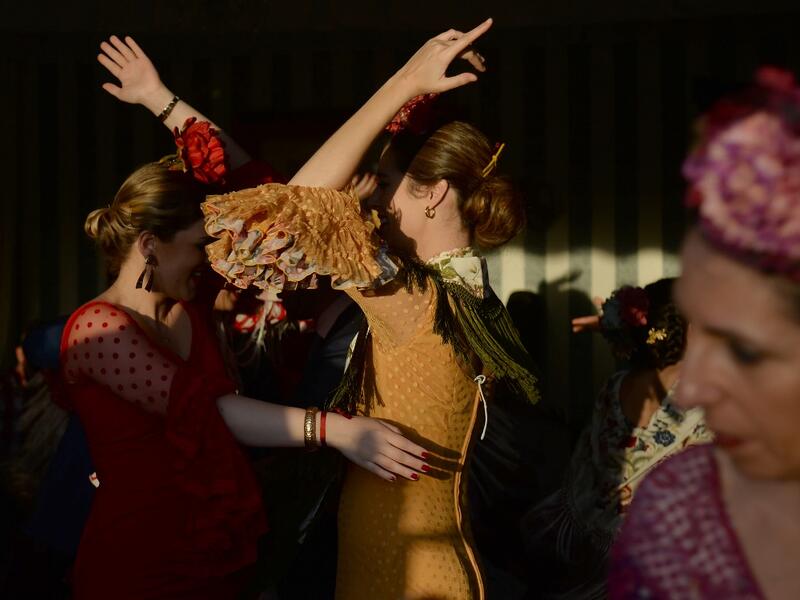 Women in traditional Sevillian dresses dance in a "caseta" (stall) during the "Feria de Abril" (April Fair) festival in Seville on May 6, 2019. CRISTINA QUICLER / AFP