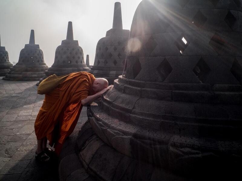 Buddhist monk prays on the eve of Buddha's birthday also known as Vesak celebrations, at Borobudur temple in Magelang, Central Java province, on May 18, 2019. Buddhists are celebrating Vesak, which commemorates the birth of Buddha, his attaining enlightenment and his passing away on the full moon day of May which falls on May 18 this year. OKA HAMIED / AFP