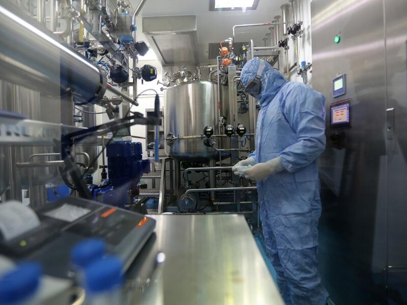 Pharmaceutical factory workers dressed in chemical safety suits work in the bioreactor room at the Actoverco plant in Karaj, about 40 kilometres (nearly 25 miles) west of Iran's capital Tehran, on February 18, 2020. AFP