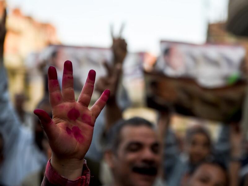 Egyptian people show their inked hands after voting at a polling station during the third day of a referendum on constitutional amendments, at a school in shamma village in the northern Nile delta province of Menoufia, on April 22, 2019.  Mohamed el-Shahed / AFP