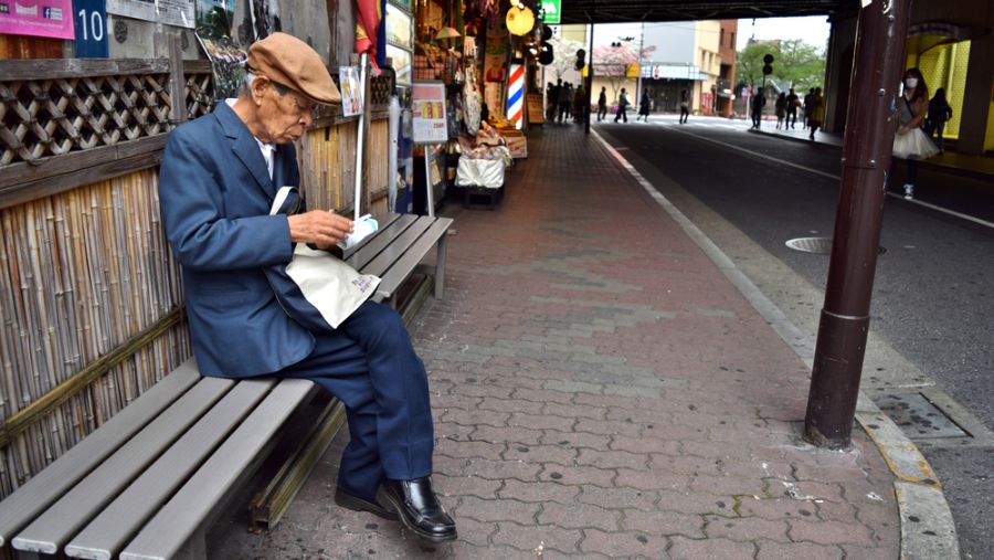 Elderly Japanese Man sitting alone in the street