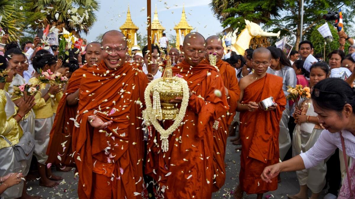 Cambodian Buddhist monks carry an urn which allegedly contains the remains of one of Buddha's bone inside during the Visak Bochea Buddhist celebration at a pagoda in Phnom Penh on May 18, 2019. TANG CHHIN Sothy / AFP
