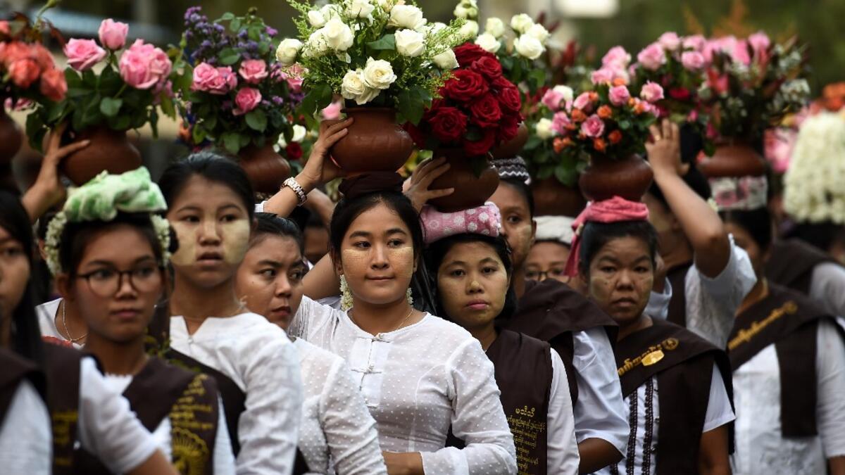 Buddhist devotees carry water and flowers during Buddha's birthday in Mandalay, on May 18, 2019. Buddhists commemorate the birth of Buddha, his attaining enlightenment and death on the day of the full moon, which falls on May 18 this year. YE AUNG THU / AFP