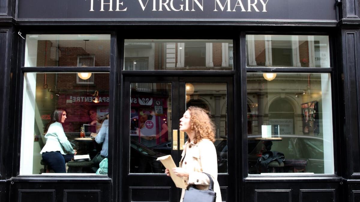 A woman walks past the Virgin Mary pub, which opened recently selling non-alcoholic drinks and is known as the 'pub with no beer', in the city centre of Dublin on May 16, 2019. PAUL FAITH / AFP