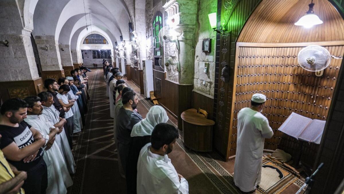 An imam leads Muslim worshippers in prayer at a mosque in Maaret al-Noman in Syria's northwestern Idlib province late on May 31, 2019, on the occasion of Lailat al-Qadr, which marks the night in the fasting month of Ramadan during which the Koran was first revealed to Prophet Mohammed in the seventh century.  OMAR HAJ KADOUR / AFP