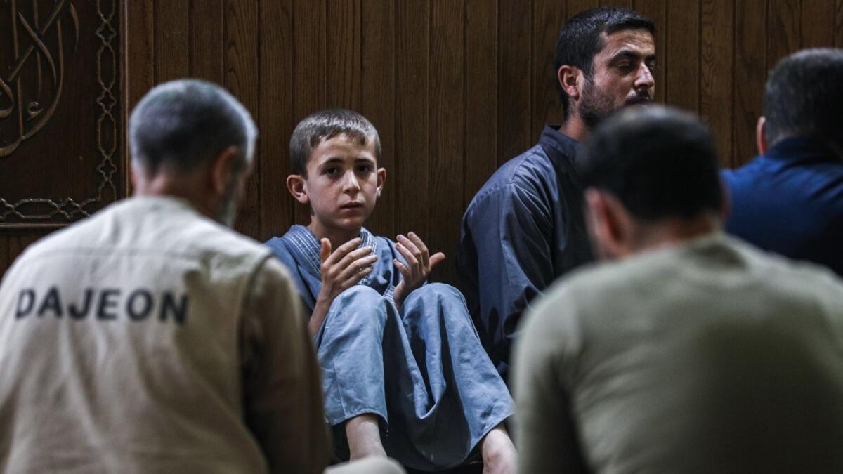 A young boy prays with other Muslim worshippers at a mosque in Maaret al-Noman in Syria's northwestern Idlib province early on June 1, 2019, on the occasion of Lailat al-Qadr, which marks the night in the fasting month of Ramadan during which the Koran was first revealed to Prophet Mohammed in the seventh century.  OMAR HAJ KADOUR / AFP