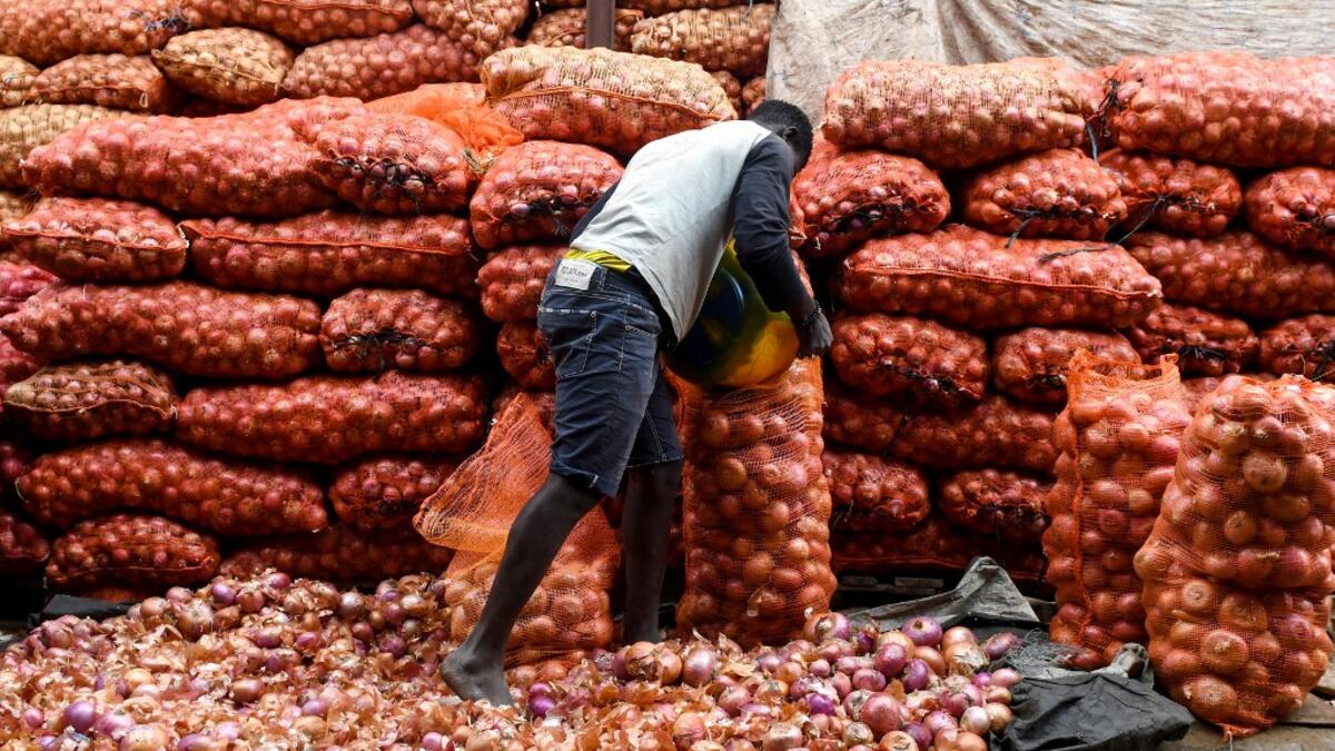 A seller packs onions in a bag in Camberene market in Dakar, on June 2, 2019. Onions are quite popular in Senegal during the Eid al-Fitr holiday, which marks the end of the fasting month of Ramadan. Onions sellers usually raise their prices, provoking consumers' protest. Seyllou / AFP
