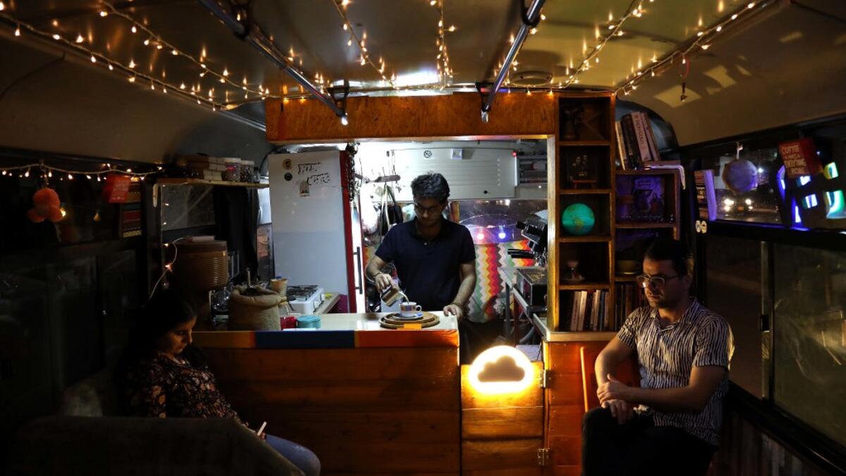 People have a drink at "The Bus Cafe Erbil" in Arbil, the capital of Iraq's Kurdish autonomous region, on June 7, 2019, on the long weekend of the Eid al-Fitr holiday which marks the end of the Muslim holy month of Ramadan.  SAFIN HAMED / AFP