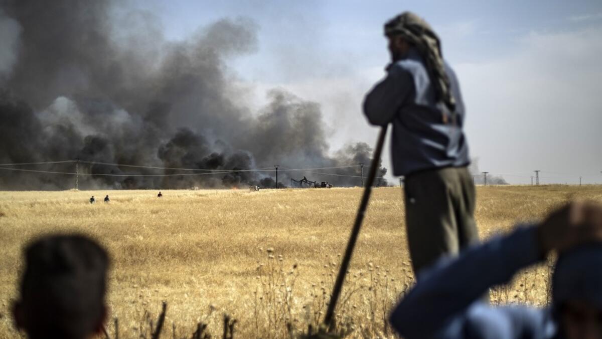 People battle a blaze next to an oil well in an agricultural field in the town of al-Qahtaniyah, in the Hasakeh province near the Syrian-Turkish border on June 10, 2019. Fires have erupted in various parts of Syria in recent weeks, with all sides blaming each other for starting them. Delil souleiman / AFP
